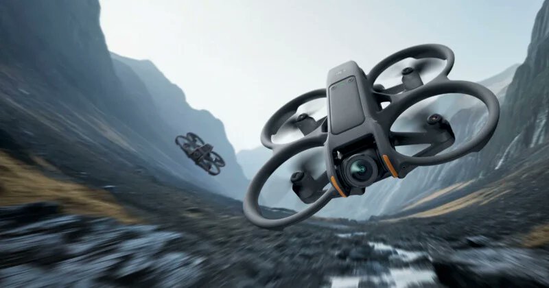 Two small drones flying through a valley