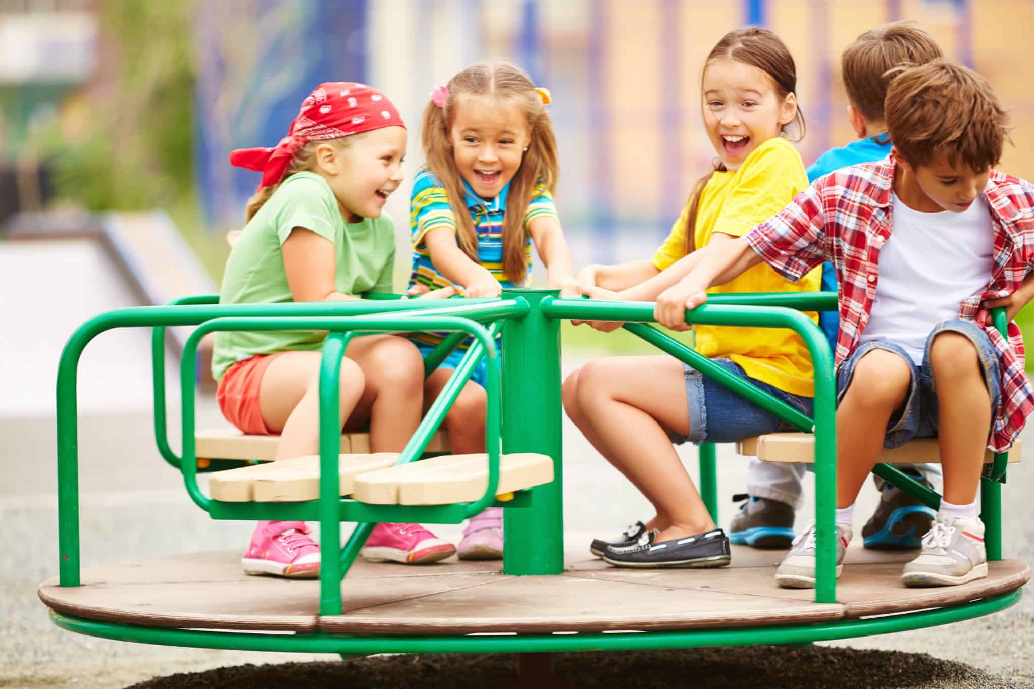 Children spinning a playground merry-go-round