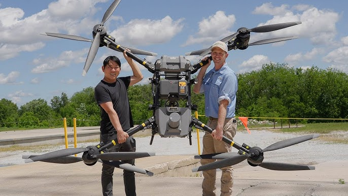 Two people holding a large quadcopter with four motors