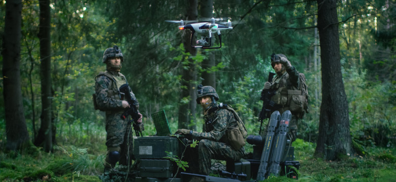 Soldiers operating a drone in a forest